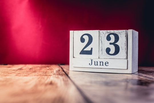 June 23rd. Day 23 of month, calendar on business office table, workplace with vivid maroon red background. Summer time