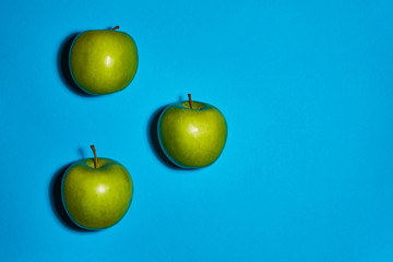 Green apple on blue background. Flat lay, top view, copy space . Food dietary concept.