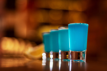 blue kamikaze shots on wooden table close up