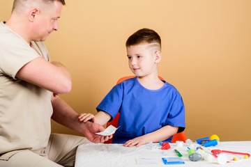 Health care. Medical examination. Boy cute child and his father doctor. Hospital worker. Medical help. Medical insurance. First aid. Medicine concept. Kid little doctor sit table medical tools