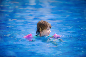 portrait of a pretty little girl playing in a swimming pool