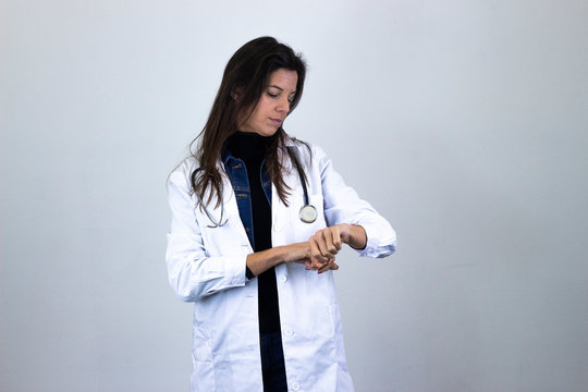 Portrait Of Pretty Caucasian Middle Age Woman Checking Time Her Watch. Pharmacist, Beauty Therapist, Doctor, Nurse, Scientist, Ophthalmologist, Beautician, Healthcare, Optometrist, Isolated On Gray Ba