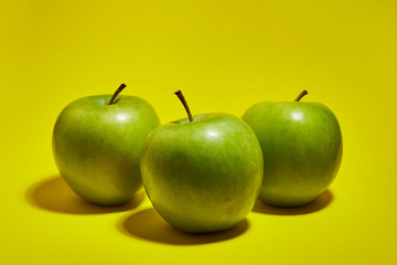 Green apple on yellow background. Flat lay, top view, copy space . Food dietary concept.