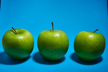 Green apple on blue background. Flat lay, top view, copy space . Food dietary concept.