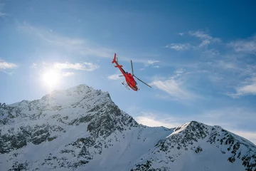 Poster Red rescue helicopter flying over the view of the snowy rocks in Alpine ski resort Zermatt near Matterhorn mountain. Winter nature landscape of Swiss Alps. Mountains with snow in Switzerland. © Pavel Kašák