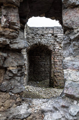 View to the old or ancient wall ruines of the stone castle or fortress through embrasure or loophole © Майджи Владимир