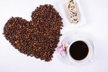 cup of coffee and heart made of scattered coffee beans