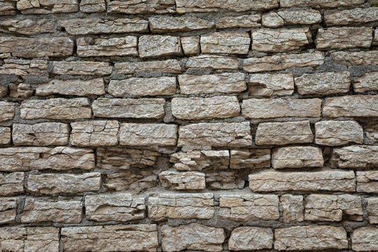 The brown and grey  cobblestone or brick tower, fortress or castle wall background or texture