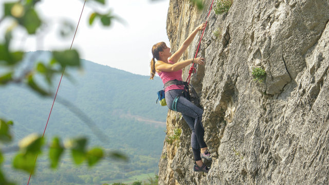 CLOSE UP: Young Woman Goes Rock Climbing Up A Mountain In Slovenian Countryside.