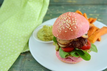 Beetroot burger with beef patties, lettuce, tomato, mushroom. Served with guacamole and sweet potato fries