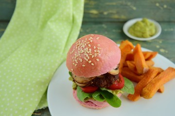 Beetroot burger with beef patties, lettuce, tomato, mushroom. Served with guacamole and sweet potato fries