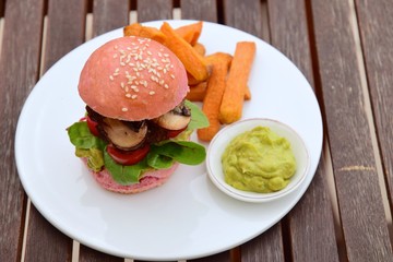 Beetroot burger with beef patties, lettuce, tomato, mushroom. Served with guacamole and sweet potato fries