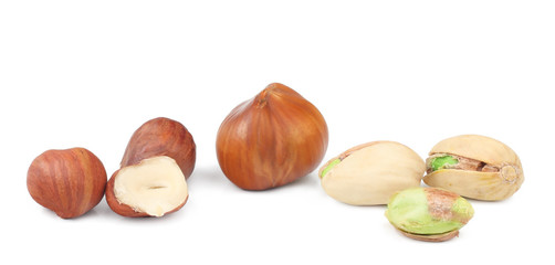 Hazelnuts and pistachios isolated on white background