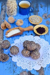 Vegan energy balls with Maqui berry powder, acai powder, quinoa, fig, sunflower seed and coconut flakes on doily paper