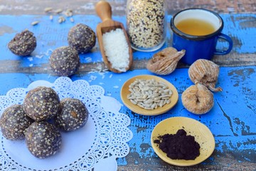 Vegan energy balls with Maqui berry powder, acai powder, quinoa, fig, sunflower seed and coconut flakes on doily paper