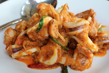 Stir-fried squid with salted duck eggs  on white plate. Food concept. 