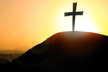 Silhouette cross on Calvary mountain sunset background. Easter concept