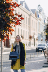 cute attractive blonde woman with packages on the street in sunny weather. shopping and positive emotions.