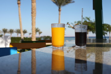 Two cocktail glasses infront of sea blue water
