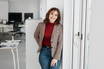 Happy relaxed young businesswoman in office
