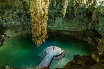 Woman enjoying the view of Suytun Cenote from the top Yucatan Mexico North America - obrazy, fototapety, plakaty