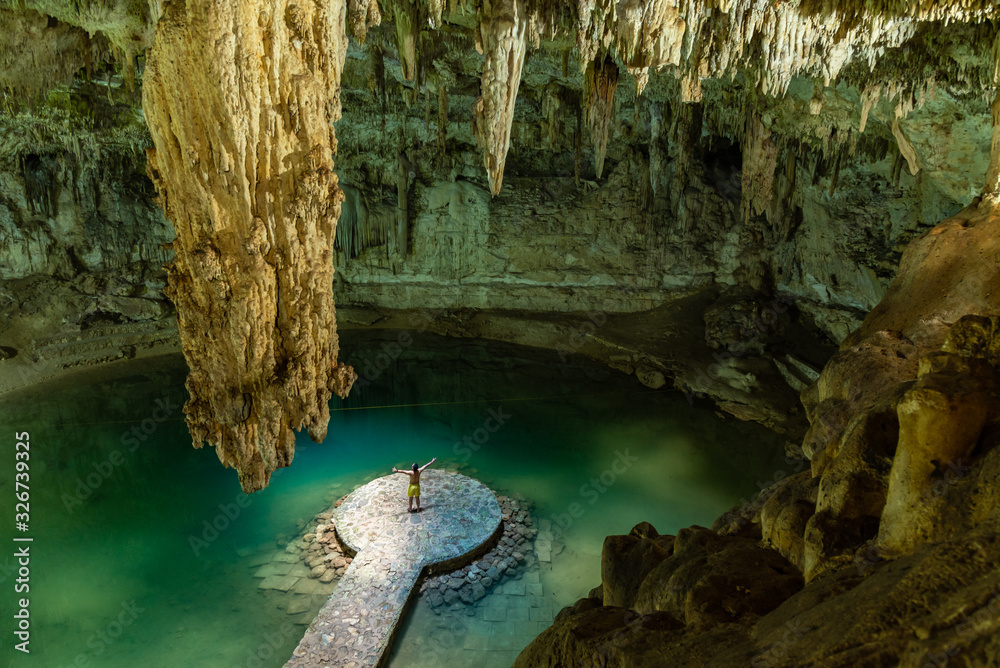 Wall mural man enjoying the view of suytun cenote from the top yucatan mexico north america