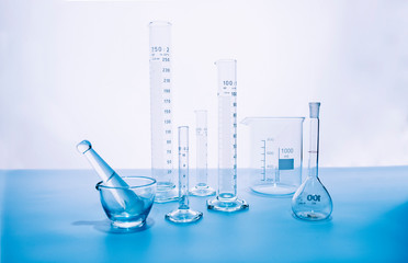 Laboratory test equipment with blue liquid inside on white background