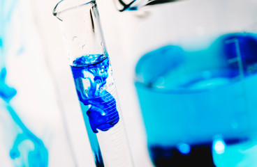Laboratory test equipment with blue liquid inside on white background