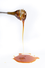 Honey falling from a metal honey spoon
