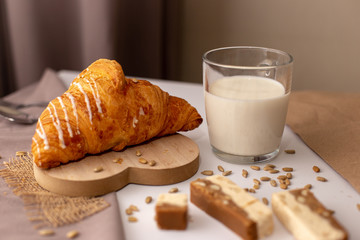 Appetizing Croissant, a glass of milk and slices of sweet sorbet. Tasty breakfast