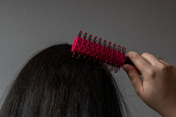 Frau kämmt ihre lange schwarzen Haare 