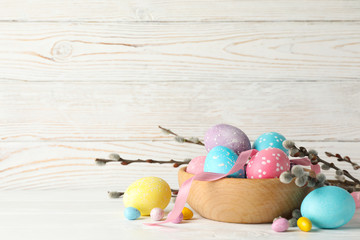 Composition with Easter eggs on white wooden background, space for text