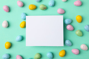 Multicolor Easter eggs and space for text on mint background