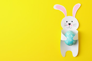 Decorative bunny and Easter egg on yellow background, space for text