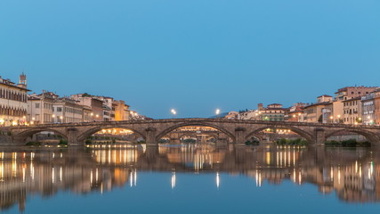 Twilight sky scene of Ponte Alla Carraia and Santa Trinita Holy Trinity Bridge day to night timelapse over River Arno