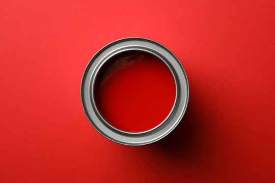Paint can on red background, top view
