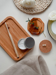 bamboo toothbrush with natural paste and beige cotton towel, little plant on the white background. Concept eco friendly, zero waste.