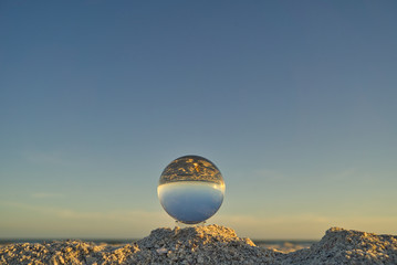Nahaufnahme einer Glaskugel am Strand auf Sanibel Island mit Meer und Horizont im Hintergrund