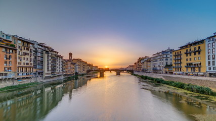 Fototapeta na wymiar Cityscape view on Arno river with famous Holy Trinity bridge timelapse on the sunset in Florence
