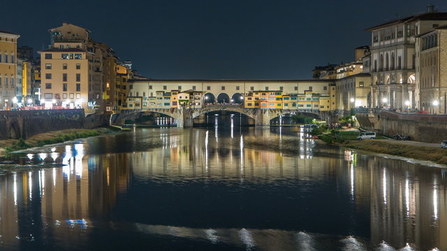 Famous Ponte Vecchio bridge timelapse over the Arno river in Florence, Italy, lit up at night
