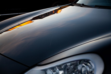  beautiful reflection on a detail of black luxury car hood