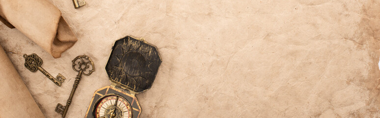 top view of vintage keys and compass on aged paper, panoramic shot © LIGHTFIELD STUDIOS