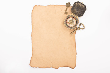 top view of vintage keys and compass on aged paper isolated on white
