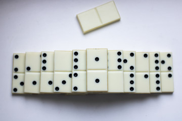Steps or stairs from an old domino on a white background with shadows and place for text. An empty domino bone lies nearby. View from above
