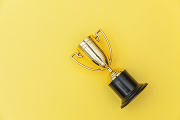 Winner or champion gold trophy cup isolated on yellow colorful background