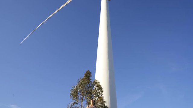 Woman looking up to wind turbine in Fafe, Portugal