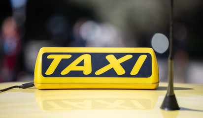 Taxi sign yellow coloe detail, defocused city street background
