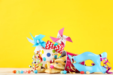 Purim holiday composition. Cookies with buckets and party supplies on yellow background