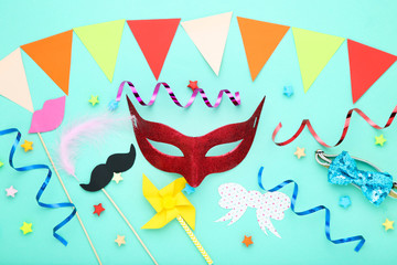 Purim holiday composition. Party supplies with paper flags on blue background