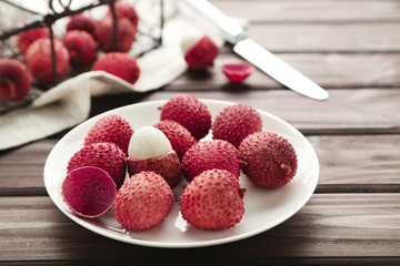Tasty lychee in plate on wooden table